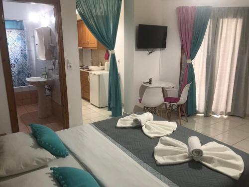 a bedroom with a bed with towels on it at Vrisi Apartments & Villa in Pitsidia