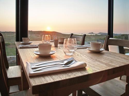 - une table en bois avec des verres et des ustensiles de cuisine avec vue dans l'établissement Logis Le Château de Sable, à Porspoder