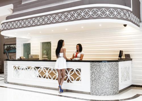 two women standing at a counter in front at Galeri Resort Hotel - Ultra All Inclusive in Okurcalar