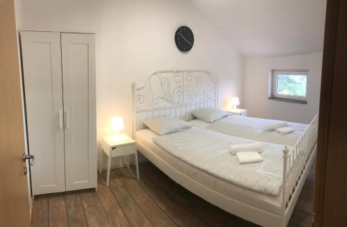una camera da letto con un letto bianco con due asciugamani di Apartment Noa Zrće Beach a Skunca