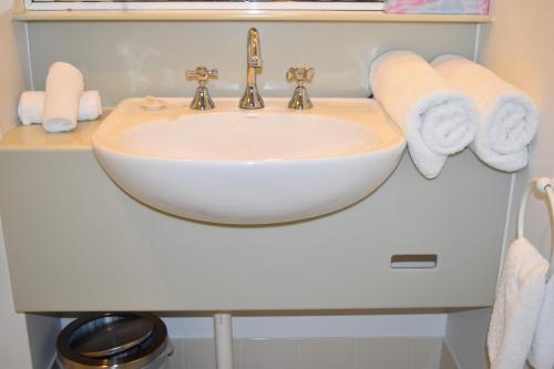 a bathroom with a sink and towels on a shelf at Comfort Resort Waters Edge in Port Macquarie