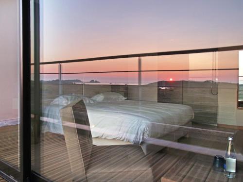 - une chambre avec un lit sur un balcon dans l'établissement Logis Le Château de Sable, à Porspoder
