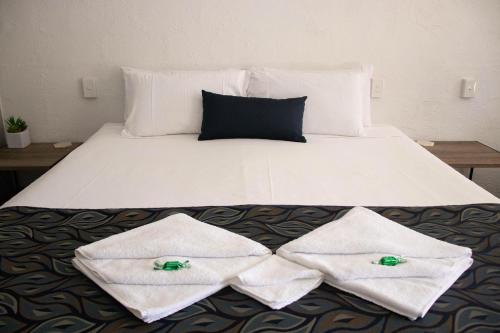 a bed with two white towels on it at Bundaberg Spanish Motor Inn in Bundaberg