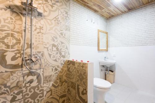 a bathroom with a shower and a toilet in it at The Dewi Premier Nusa Penida in Nusa Penida