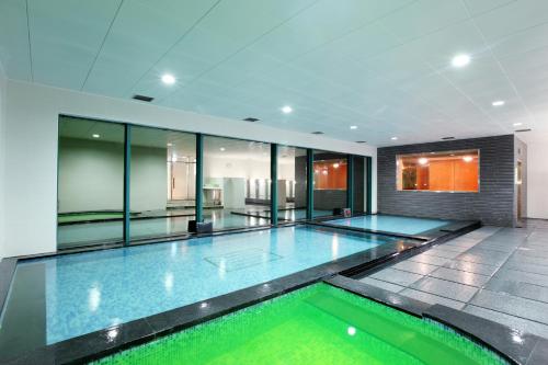 an indoor swimming pool in a building with glass walls at Hanwha Resort Daecheon Paros in Boryeong