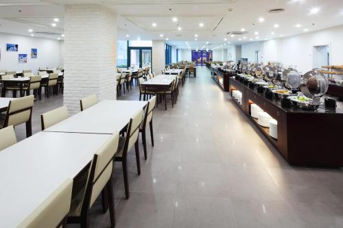 una sala da pranzo con lunghi tavoli e sedie di Hanwha Resort Daecheon Paros a Boryeong