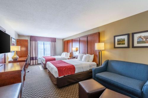 a hotel room with two beds and a couch at Comfort Suites Escanaba in Escanaba