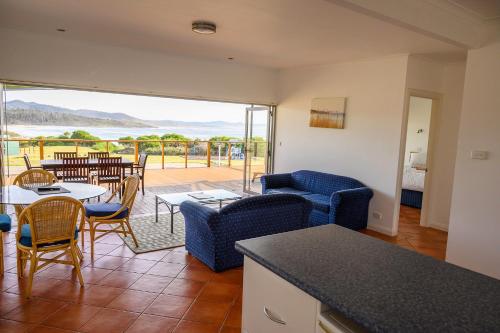 a kitchen and living room with a view of the ocean at White Sands Estate in Falmouth