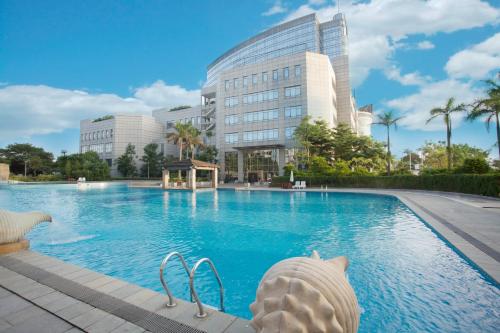 a swimming pool in front of a building at KB Hotel Qingyuan in Qingyuan