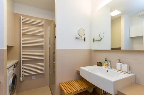 a bathroom with a sink and a washing machine at Apartments Lux by Locap Group in Portorož