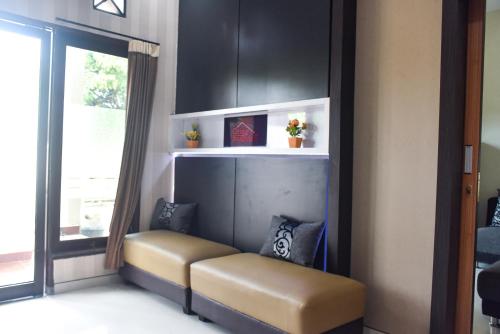 a bench in a living room with a window at RedDoorz Syariah near Gelora Delta Sidoarjo 2 in Sidoarjo