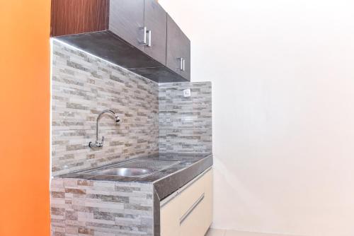 a kitchen with a sink and a brick wall at RedDoorz Syariah near Gelora Delta Sidoarjo 2 in Sidoarjo