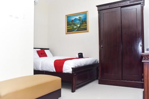 a small bedroom with a bed and a cabinet at RedDoorz Syariah near Gelora Delta Sidoarjo 2 in Sidoarjo