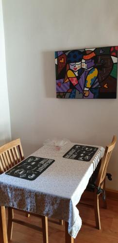 un tavolo in una stanza con un dipinto sul muro di Appartamento La Chiocciola a Treviso