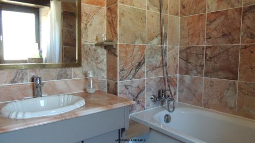 een badkamer met een bad, een wastafel en een bad bij Gîte Layon 6 places Moulin de la Placette in Faye-dʼAnjou