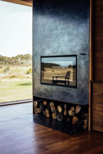 a living room with a fireplace with a mirror at Seastacks at The Denison in Bicheno