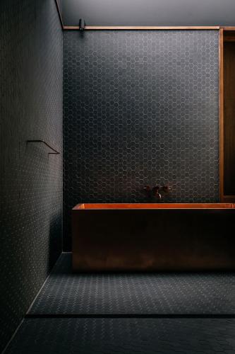 a bathroom with a sink and a black wall at Seastacks at The Denison in Bicheno