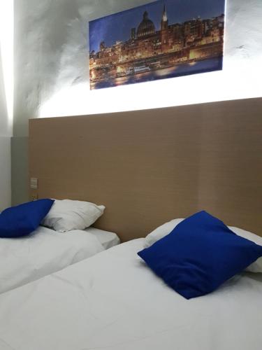 two beds with blue pillows sitting next to each other at Le Malte House St. Julians in St Julian's