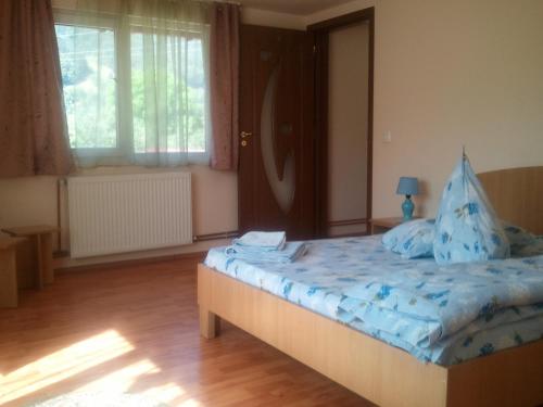 Un dormitorio con una cama con sábanas azules. en Pensiunea Ilaria, en Bran