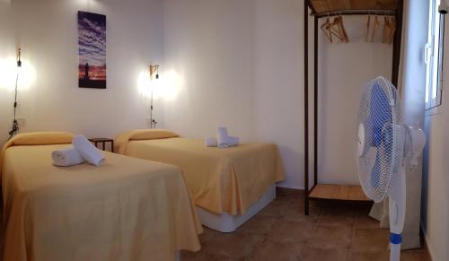 um quarto com 2 camas e uma ventoinha em Can Angel em Sant Francesc Xavier