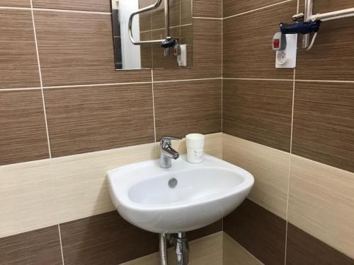 ein Bad mit einem Waschbecken und einem Spiegel in der Unterkunft Студия Париж в Александровском саду in Adler