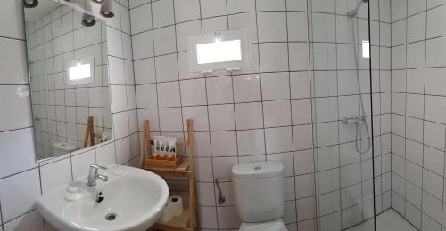 La salle de bains est pourvue de carrelage blanc, de toilettes et d'un lavabo. dans l'établissement Can Angel, à Sant Francesc Xavier