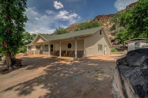 a small white house with a mountain in the background at Pecan Point by KABINO Mountain Trail Access Foosball Table Private Yard Firepit WiFi Grill in Hurricane