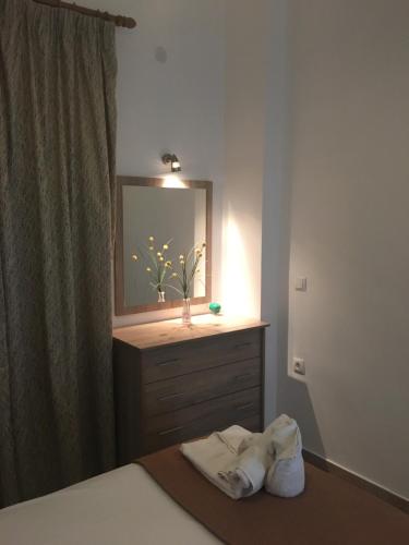 a bedroom with a bed with a dresser and a mirror at Regina Apartments in Lassi