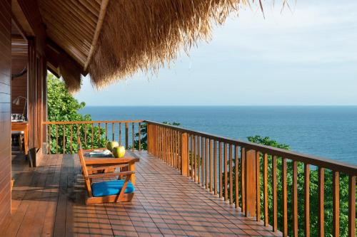 a balcony with a table and a view of the ocean at Lelewatu Resort Sumba in Watukarere