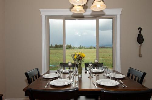 a dining room table with a large window at Teton Harmony by KABINO Hot Tub Pool Table Fire Pit Mtn Views 2 Levels 2 Living Rooms WiFi Grill in Driggs