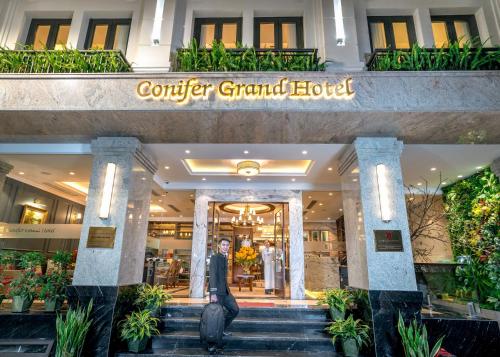 een man die de trap af loopt voor een hotel bij Conifer Grand Hotel in Hanoi