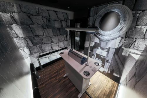 a bathroom with a stone wall and a toilet at KKR Hotel Osaka in Osaka