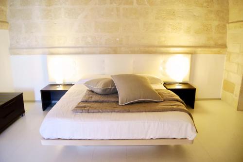 una camera con un grande letto con due lampade di B & B Sotto la Volta a Massafra