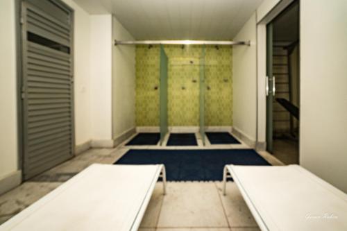 two beds in a room with a shower at Max Savassi Premier 14 in Belo Horizonte