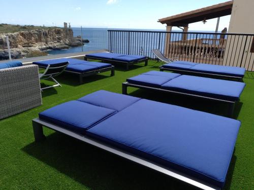 
a row of lounge chairs sitting on top of a beach at Hotel Rocamar in Cala Figuera
