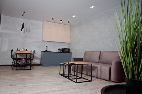 a living room with a couch and a table and a kitchen at Prestige Apartments Kalnyshevskogo in Dnipro