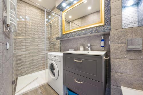 a bathroom with a washing machine and a sink at Dwie Sosny z sauną, Sun & Snow in Ustronie Morskie
