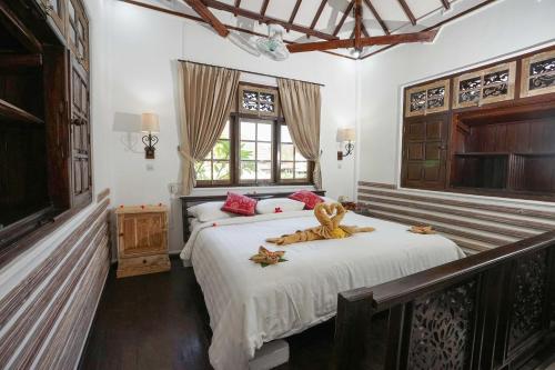 a bedroom with a bed with a teddy bear on it at Martas Hotel in Gili Trawangan