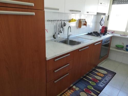 eine Küche mit Holzschränken und einem Waschbecken in der Unterkunft Lisa Apartment in Gaeta