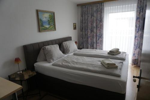 a bedroom with a bed and a window with towels on it at Pension-Ferienwohnung Rotar in Faak am See