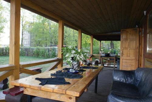 una mesa de madera en un porche cubierto en Izbushka, en Riga