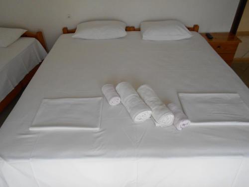 Una cama blanca con cuatro toallas enrolladas. en Haus Dusseldorf, en Potos