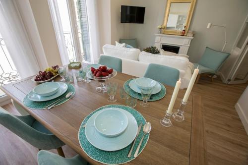 a dining room table with plates and bowls of fruit on it at Gr Suites Boutique Catedral in Málaga