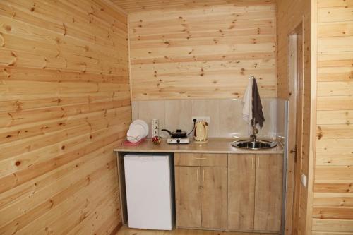una pequeña cocina con paredes de madera y una encimera en Green Villa Tskaltubo en Tskaltubo