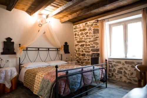 a bedroom with a bed in a room with a stone wall at B&B Sopra il Portico in San Giovanni Bianco