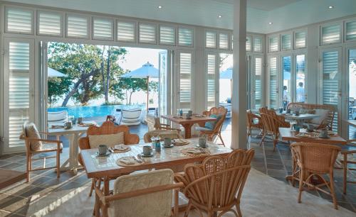 um restaurante com mesas e cadeiras e uma piscina em Cape Kudu Hotel, Koh Yao Noi em Ko Yao Noi