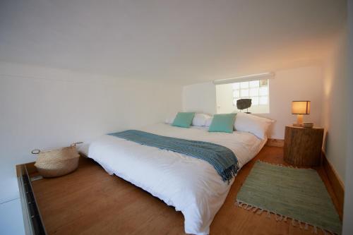 une chambre avec un grand lit blanc avec une fenêtre dans l'établissement 6 Rue Coste Corail, à Cannes