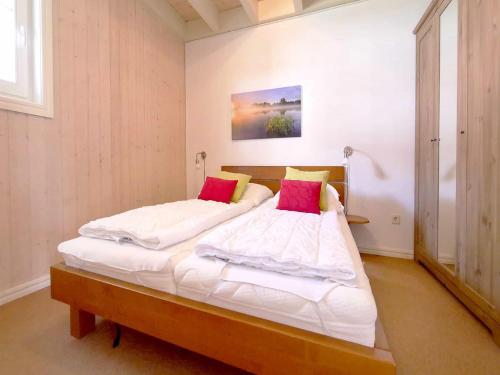 a bedroom with two beds with white sheets and pink pillows at Ferienpark Bad Saarow in Bad Saarow