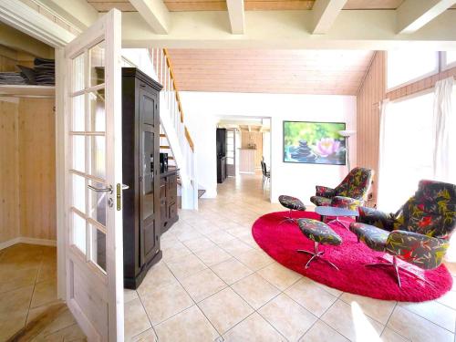 a living room with two chairs and a red rug at Ferienpark Bad Saarow in Bad Saarow