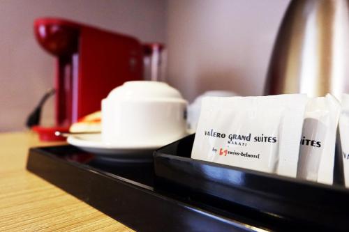 a black counter with a coffee maker and books on it at Valero Grand Suites by Swiss-Belhotel in Manila